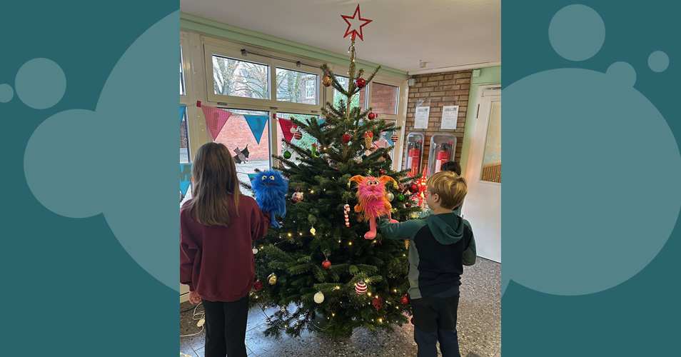 Kinder schmücken den Weihnachtsbaum im Eingangsbereich der Schule