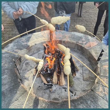 Teaserbild Kinder mit Stockbrot am Feuer