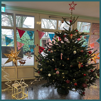 Geschmückter Weihnachtsbaum im Eingang der Schule